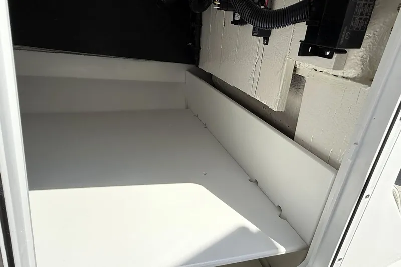 Slide: The Image of Storage compartment of 2026 Scarab 235 SE boat, featuring clean white interior. - 26