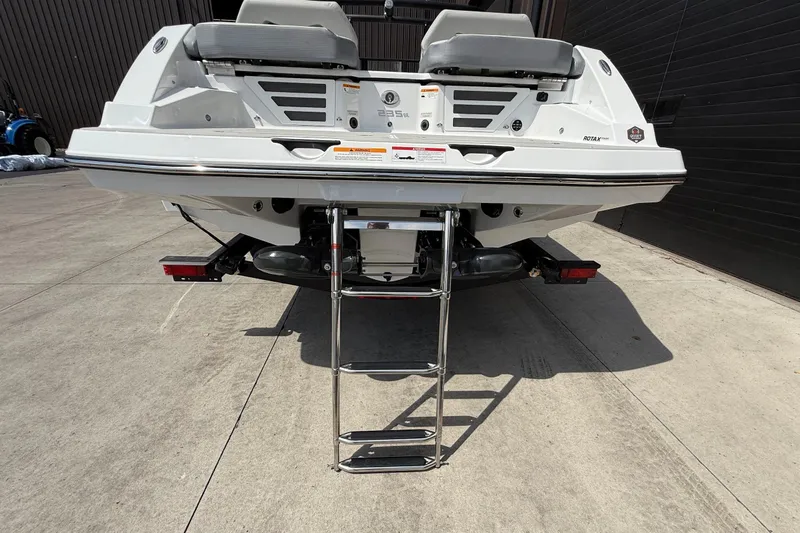 Slide: The Image of 2026 Scarab 235 SE boat rear view with ladder on concrete surface. - 4