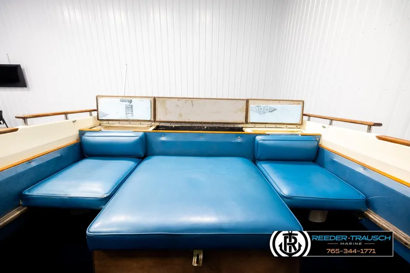 Slide: The Image of 1977 Searay 220 OV boat interior with blue seating in a bright showroom. - 19