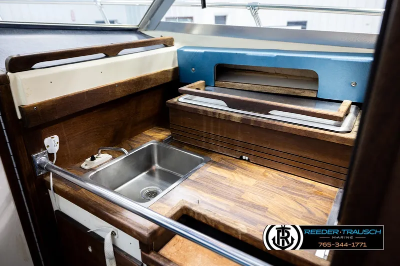 Slide: The Image of 1977 Searay 220 OV boat interior with wooden kitchenette and stainless steel sink. - 24