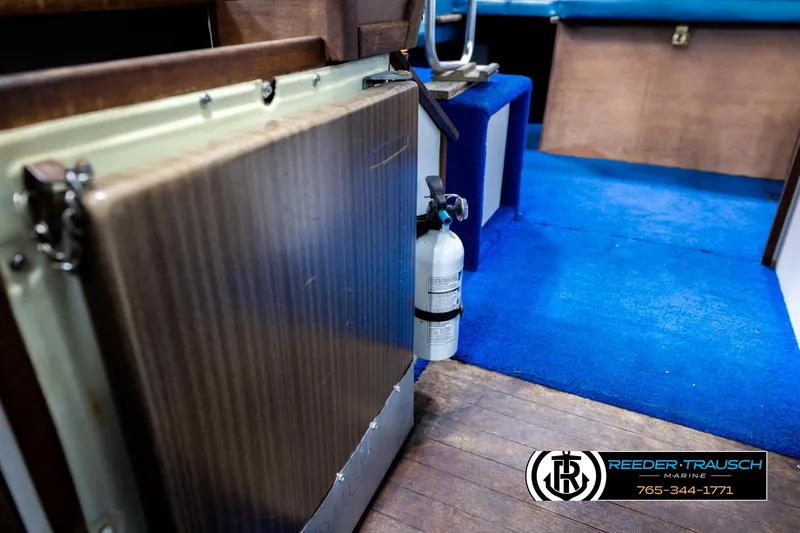 Slide: The Image of 1977 Searay 220 OV interior with blue carpet and fire extinguisher. - 26