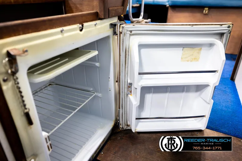 Slide: The Image of Open refrigerator inside a 1977 Searay 220 OV boat, showcasing interior storage space. - 27