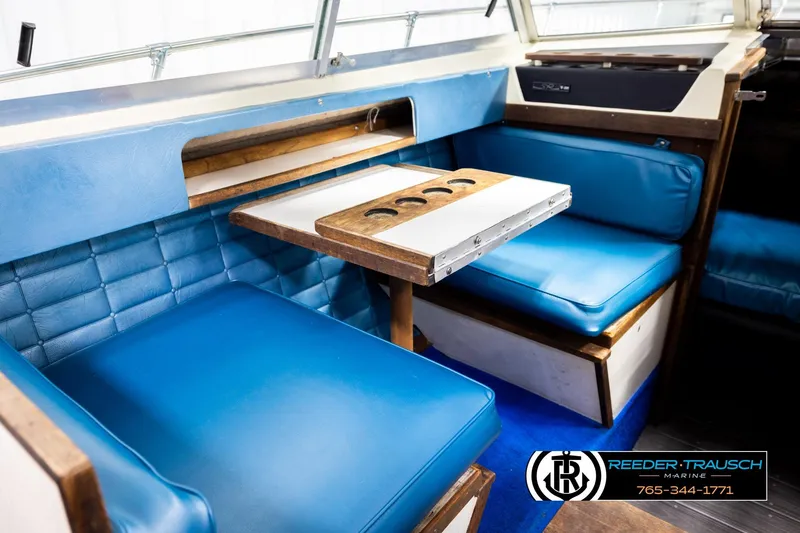 Slide: The Image of 1977 Searay 220 OV boat interior with blue seating and wooden table. - 28
