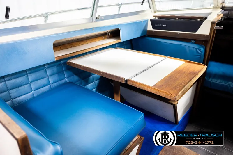 Slide: The Image of 1977 Searay 220 OV boat interior with blue seating and wooden table. - 29