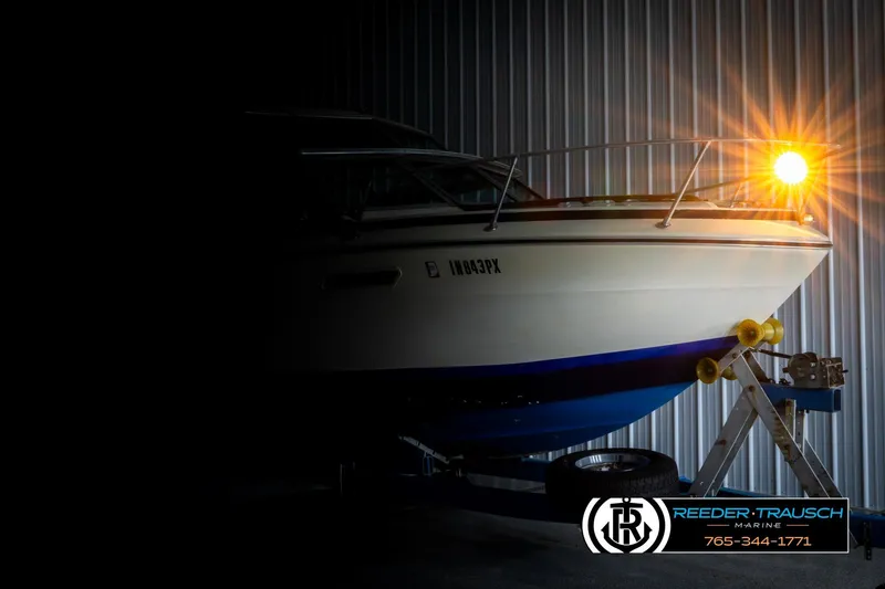 Slide: The Image of 1977 Searay 220 OV boat in storage with bright light, Reeder-Trausch Marine logo. - 3