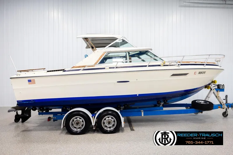 Slide: The Image of 1977 Searay 220 OV boat on trailer in indoor showroom, side view. - 4