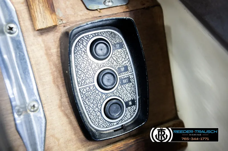 Slide: The Image of 1977 Searay 220 OV boat control panel with three buttons, wooden background. - 43