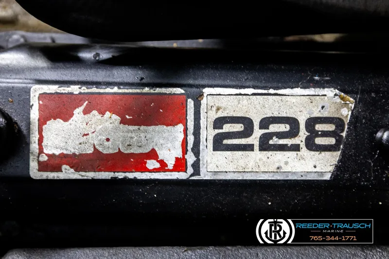 Slide: The Image of 1977 Searay 220 OV engine label with worn red and white stickers, featuring "228" text. - 54
