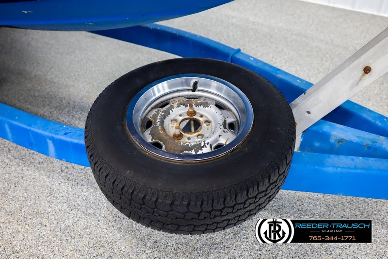 Slide: The Image of 1977 Searay 220 OV boat trailer wheel on blue frame, Reeder-Trausch Marine logo visible. - 59