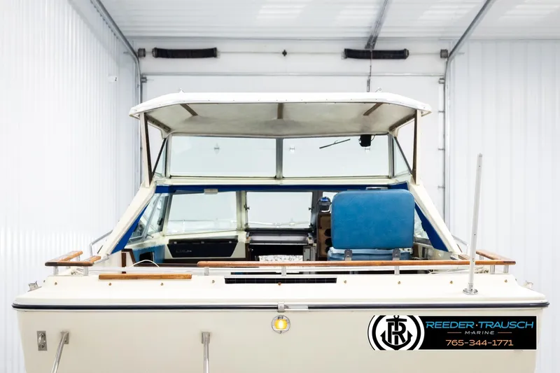 Slide: The Image of 1977 Searay 220 OV boat in storage, featuring blue seating and wooden accents. - 6