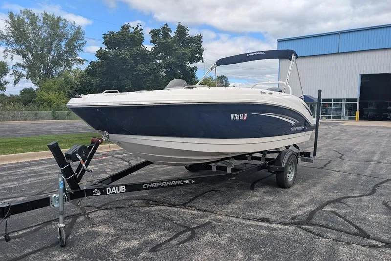 The Image of 2018 Chaparral 191 Suncoast boat on trailer, parked outdoors near a building. - 0