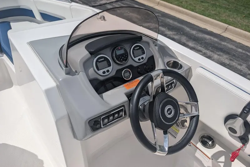 Slide: The Image of 2018 Chaparral 191 Suncoast boat dashboard with steering wheel and control panel. - 12