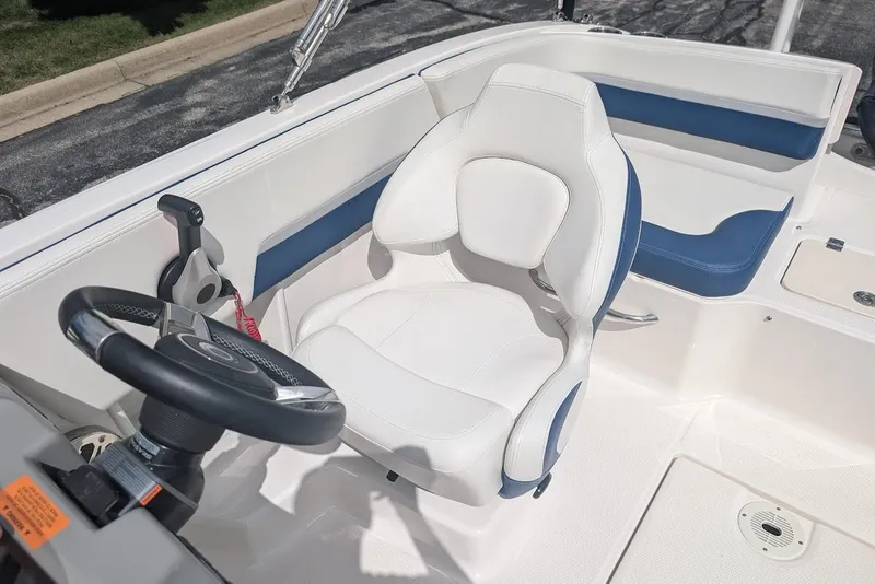 Slide: The Image of 2018 Chaparral 191 Suncoast boat interior with white and blue seating and steering wheel. - 14