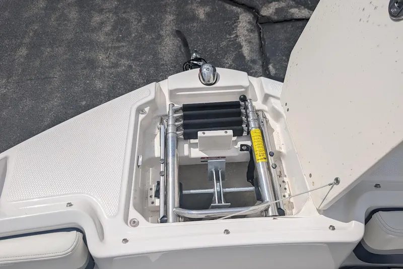 Slide: The Image of 2018 Chaparral 191 Suncoast boat compartment with hydraulic components and storage space. - 18