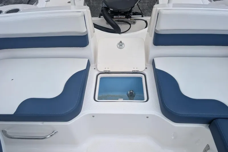 Slide: The Image of 2018 Chaparral 191 Suncoast boat interior with blue and white seating and storage compartment. - 9