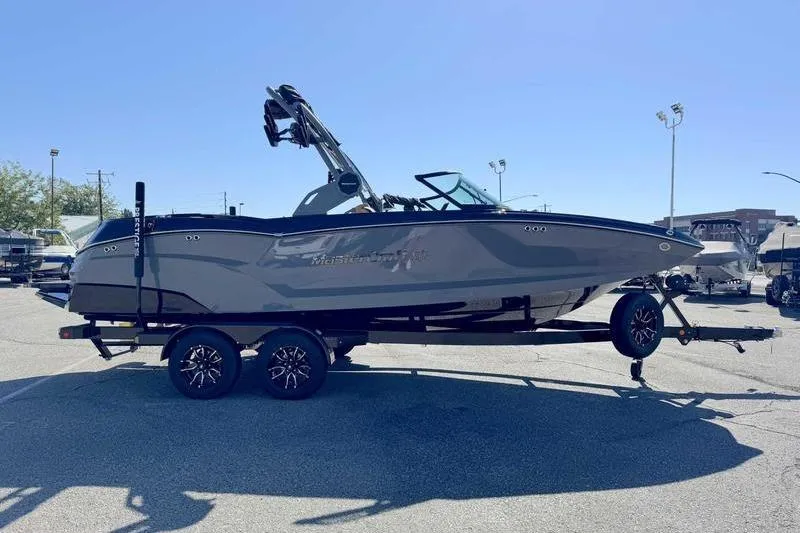 Slide: The Image of 2026 MasterCraft NXT22 boat on trailer in sunny outdoor setting. - 10