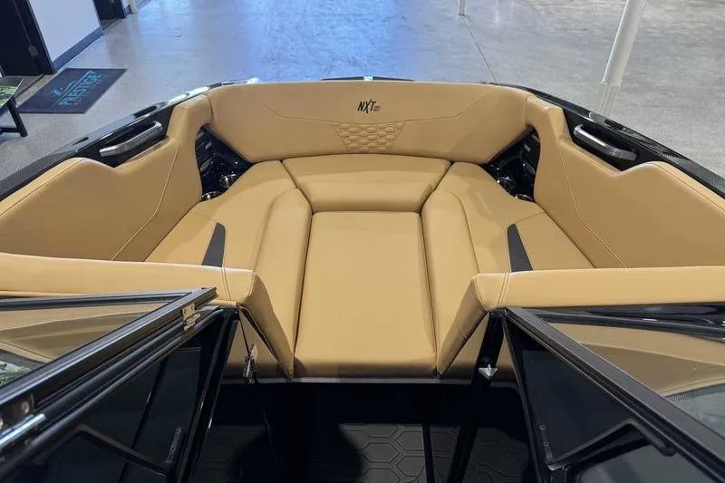 Slide: The Image of 2026 MasterCraft NXT22 boat interior with tan seating and modern design. - 12