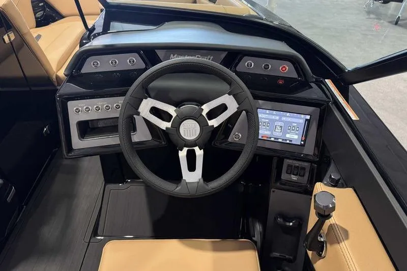 Slide: The Image of 2026 MasterCraft NXT22 boat dashboard with steering wheel and touchscreen controls. - 15