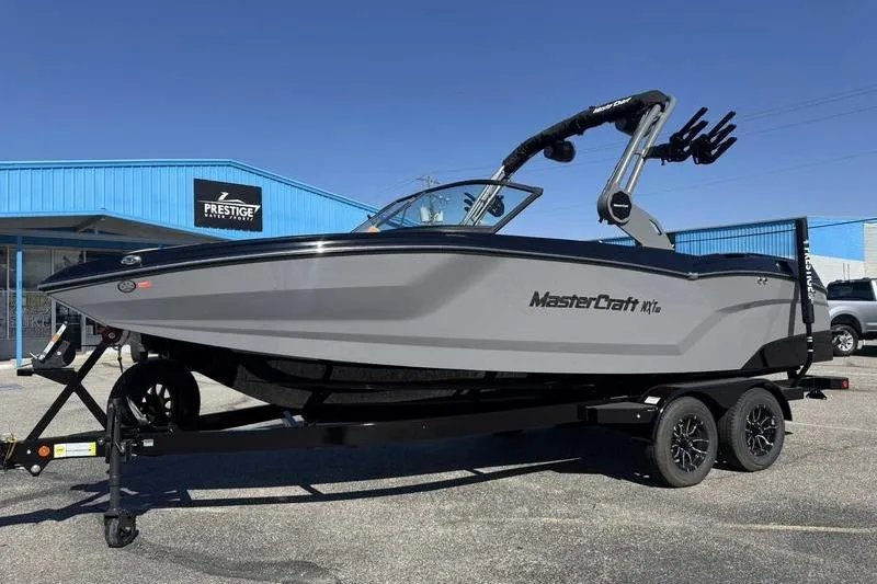 Slide: The Image of 2026 MasterCraft NXT22 boat on trailer outside Prestige dealership. - 2