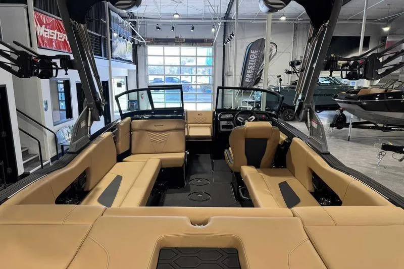 Slide: The Image of 2026 MasterCraft NXT22 boat interior with tan seating in a showroom. - 6