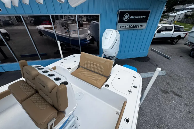Slide: The Image of 2026 Caymas 28 HB boat with tan seating, displayed at Two Georges Inc. dealership. - 14