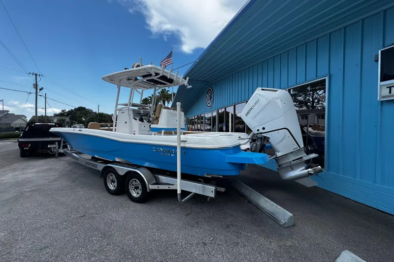Slide: The Image of 2026 Caymas 28 HB boat on trailer outside Two Georges Marina, under cloudy sky. - 2