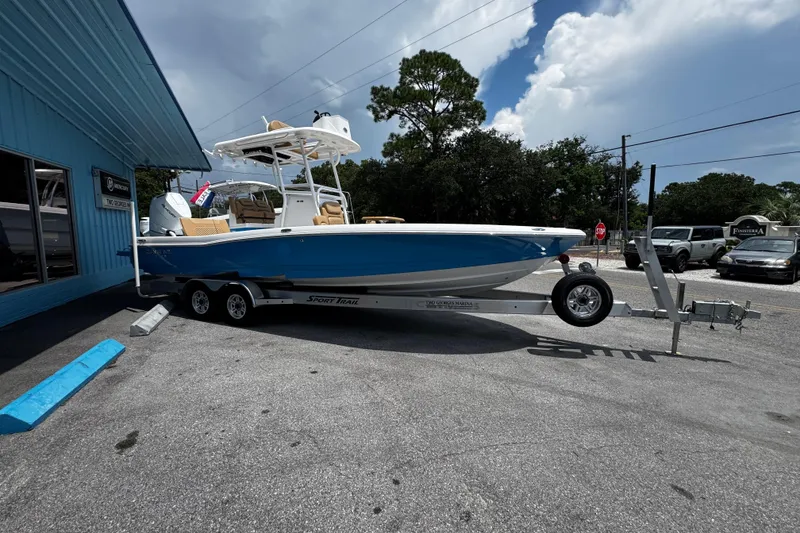 Slide: The Image of 2026 Caymas 28 HB boat on trailer, parked near blue building under clear sky. - 4