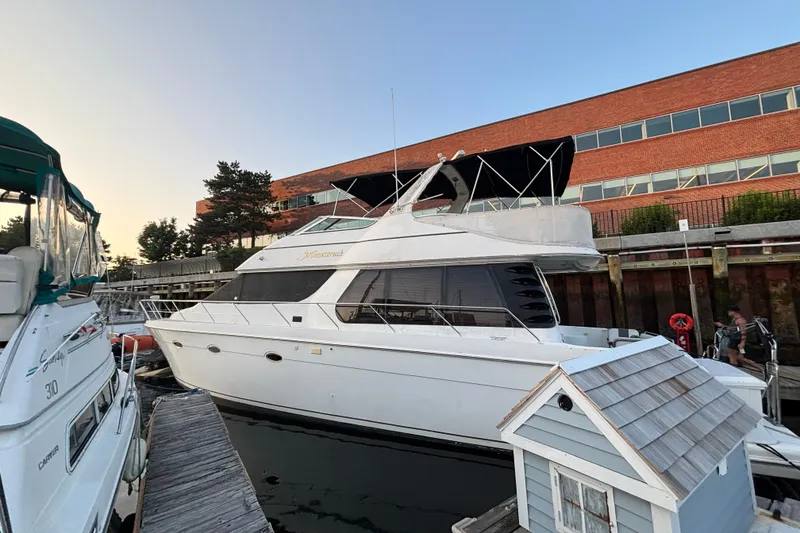 Slide: The Image of 1998 Carver 530 Voyager Pilothouse yacht docked at marina, near brick building. - 11