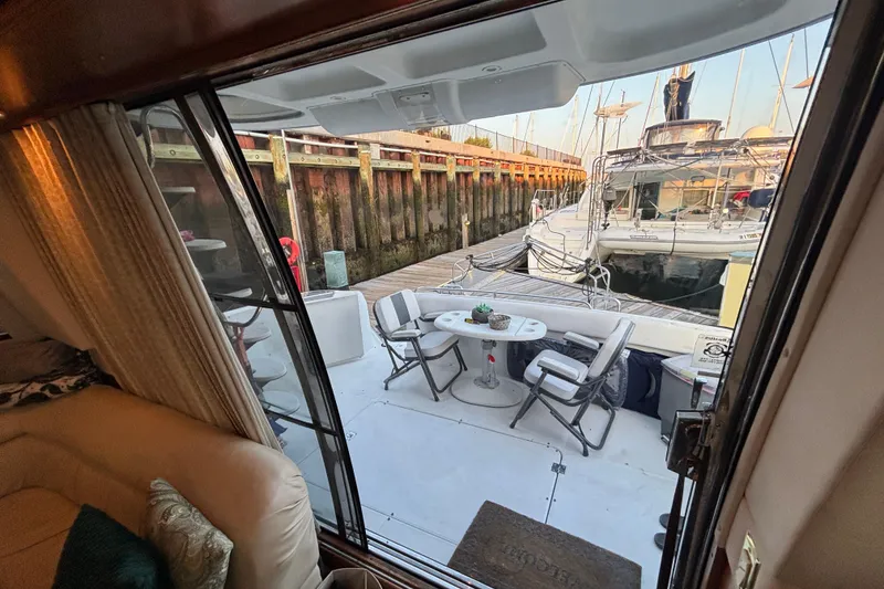 Slide: The Image of 1998 Carver 530 Voyager Pilothouse yacht interior with dockside view and outdoor seating area. - 15