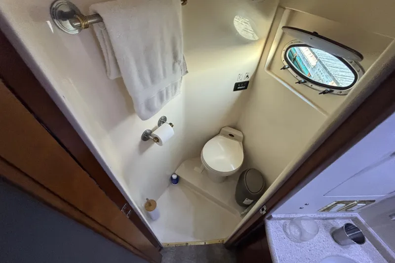 Slide: The Image of Bathroom in 1998 Carver 530 Voyager Pilothouse with porthole, toilet, and towel rack. - 33