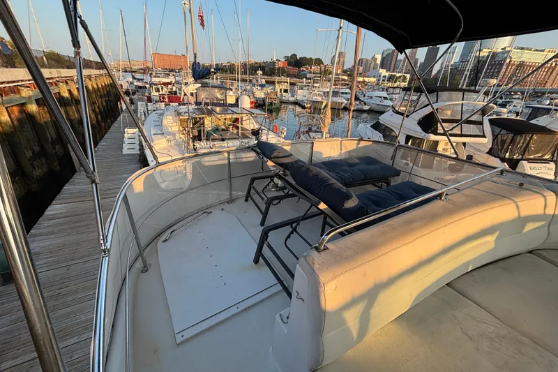 Slide: The Image of 1998 Carver 530 Voyager Pilothouse docked at marina, featuring spacious deck seating. - 41