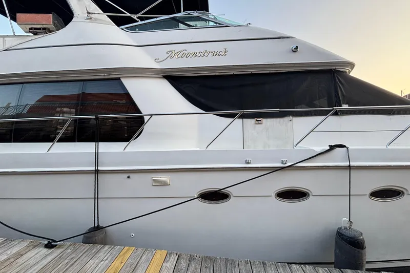 Slide: The Image of 1998 Carver 530 Voyager Pilothouse yacht docked, side view with name "Moonstruck." - 9