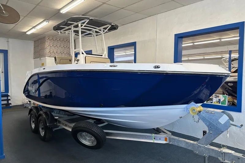 Slide: The Image of 2026 Yamaha Boats 222 FSH Sport in showroom, blue hull, on trailer. - 1