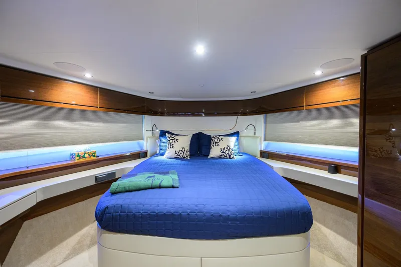 Slide: The Image of Luxurious 2020 Princess F70 yacht bedroom with blue bedding and elegant wood finishes. - 40