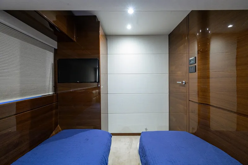 Slide: The Image of Luxurious 2020 Princess F70 yacht cabin with twin beds, TV, and sleek wood paneling. - 47