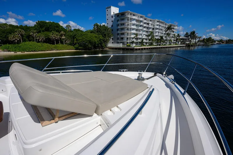Slide: The Image of Luxury Princess F70 yacht deck with sunbed, overlooking waterfront buildings and lush greenery. - 83