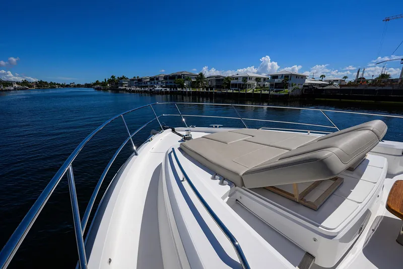 Slide: The Image of Luxury 2020 Princess F70 yacht with sunbed on deck, cruising along a scenic waterfront. - 84