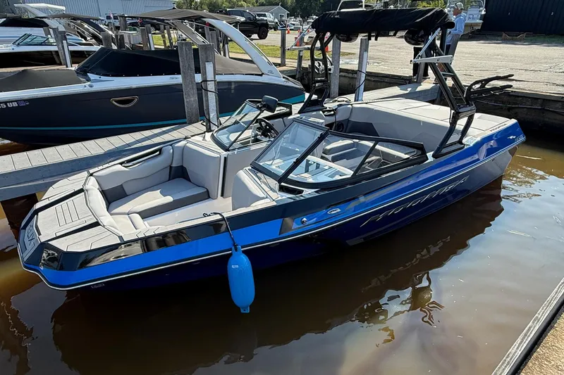 Slide: The Image of 2019 Moomba Helix boat docked, featuring sleek design and blue accents. - 0