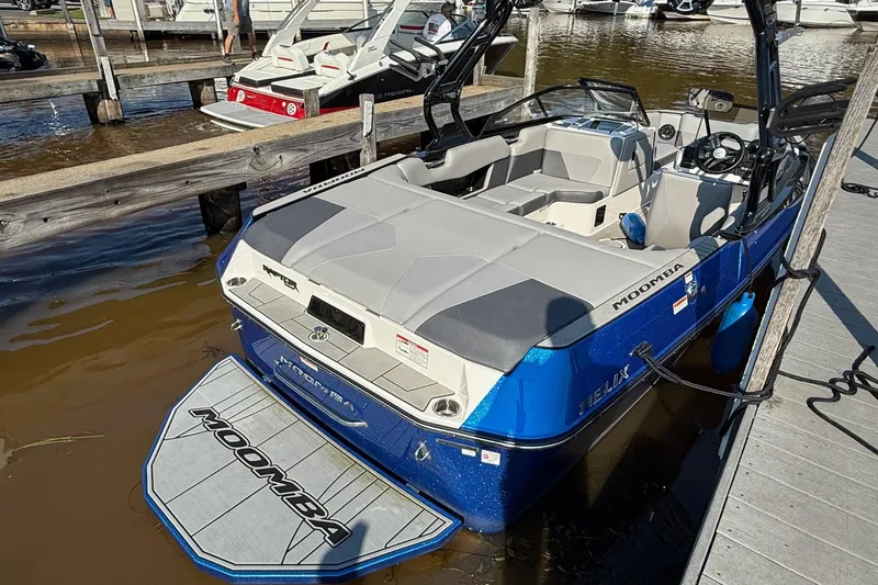 Slide: The Image of 2019 Moomba Helix boat docked at a marina, featuring sleek design and spacious seating. - 4