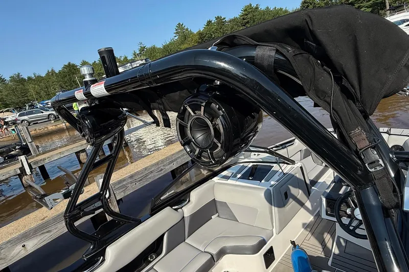 Slide: The Image of 2019 Moomba Helix boat with speakers and seating, docked by a lake. - 5