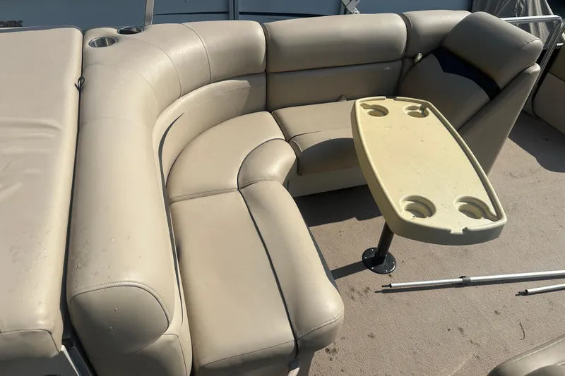 Slide: The Image of 2011 Harris Cruiser 200 boat interior with beige seating and table with cup holders. - 10