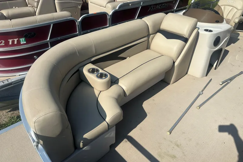 Slide: The Image of 2011 Harris Cruiser 200 boat interior with beige seating and cup holders. - 3