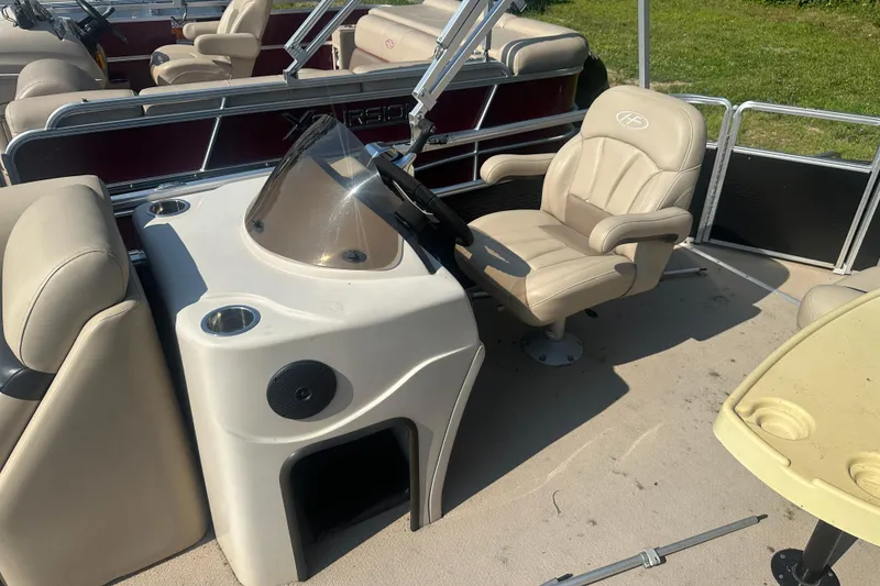 Slide: The Image of 2011 Harris Cruiser 200 boat interior with beige seating and steering console. - 4