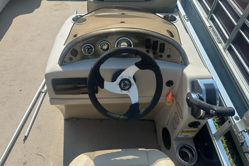 Slide: The Image of Steering console of a 2011 Harris Cruiser 200 pontoon boat, featuring gauges and controls. - 5