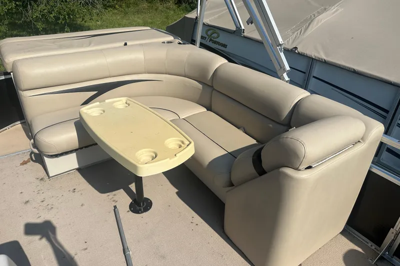 Slide: The Image of 2011 Harris Cruiser 200 pontoon boat interior with beige seating and table. - 7
