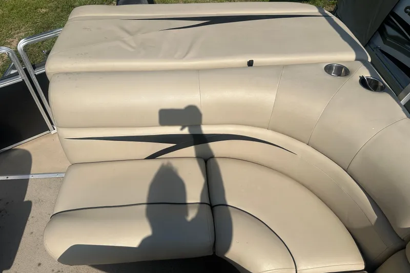 Slide: The Image of 2011 Harris Cruiser 200 boat interior with beige seating and cup holders. - 9