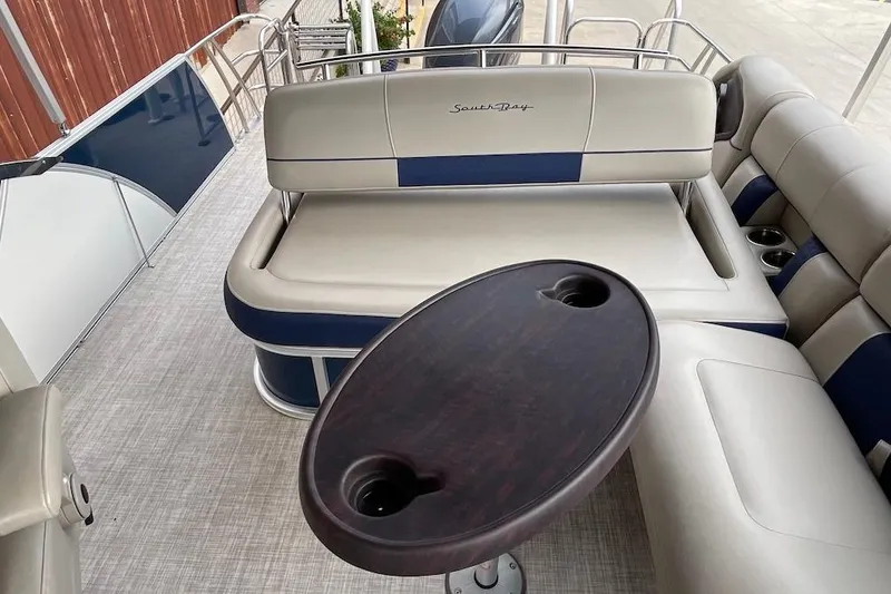 Slide: The Image of 2020 South Bay 523 boat interior with cushioned seating and oval table. - 13