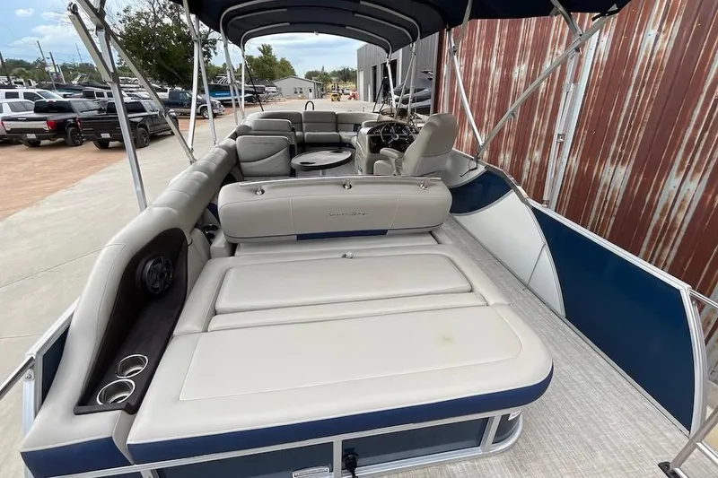 Slide: The Image of 2020 South Bay 523 pontoon boat with spacious seating and canopy in a parking area. - 4
