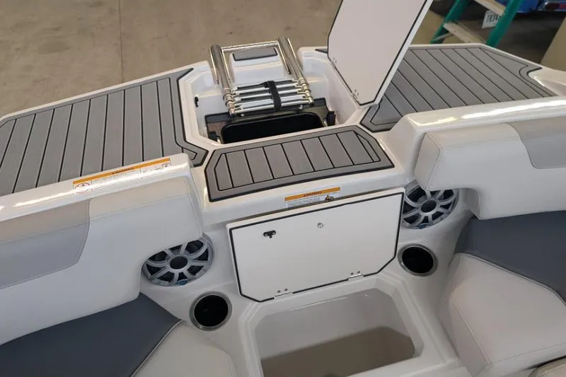 Slide: The Image of 2025 Starcraft SVX 210 IO boat interior with storage compartments and speakers. - 6