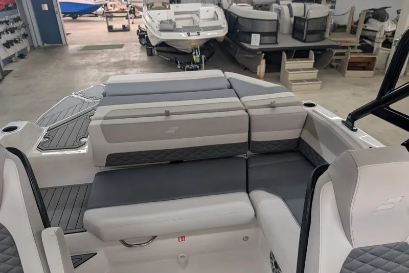 Slide: The Image of 2025 Starcraft SVX 210 IO boat interior with gray seating in showroom. - 8